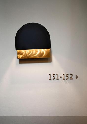 a black and gold sign on a wall at The Times Hotel in Amsterdam
