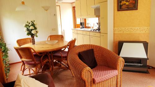 a room with a table and chairs and a kitchen at De Kleine Kriemelkuil {Het Herdertje} in Ermelo