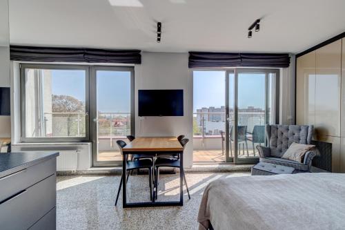 a bedroom with a bed and a table and a tv at Apartamenty Rondo in Świnoujście