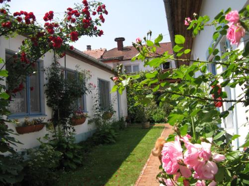 a house with pink flowers in the yard at Stieglerhof KG in Illmitz