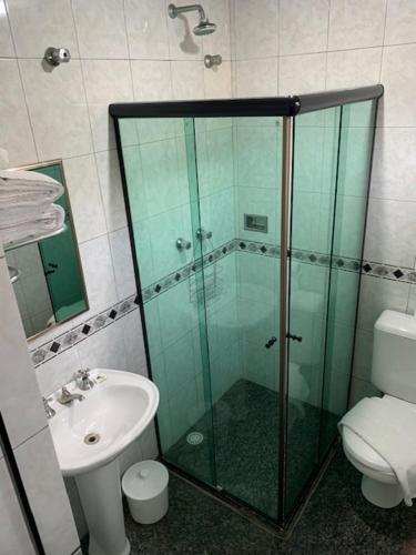y baño con ducha de cristal y aseo. en Residencial Pantanal Vila Mariana en São Paulo