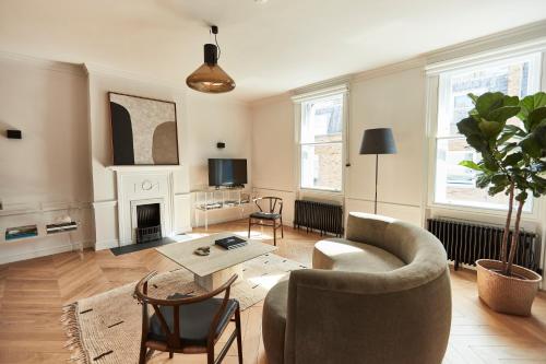 a living room with a couch and a table at Weymouth Mews in London