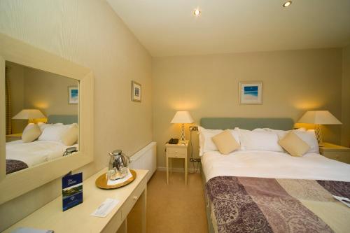 a hotel room with two beds and a mirror at Isle of Eriska Hotel Spa & Island in Benderloch
