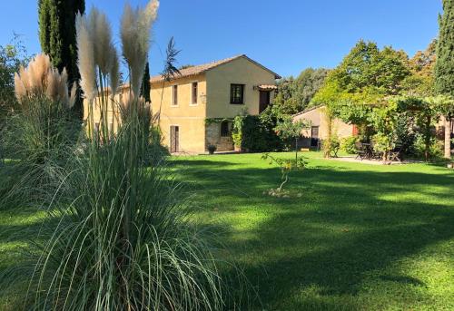 um grande quintal com uma casa ao fundo em Country Loft at Palazzo di Bagnaia em Castel del Piano