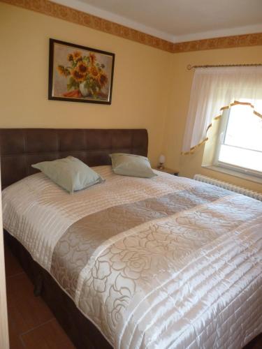 ein großes Bett in einem Schlafzimmer mit Fenster in der Unterkunft Ferien auf Rügen Familie Geist in Garz