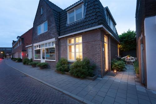 a brick house with windows and plants on a street at Darley's in Hilversum