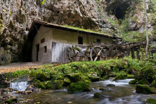 an old building in a cave next to a stream at Casa Elisa Apartments in Sarnonico