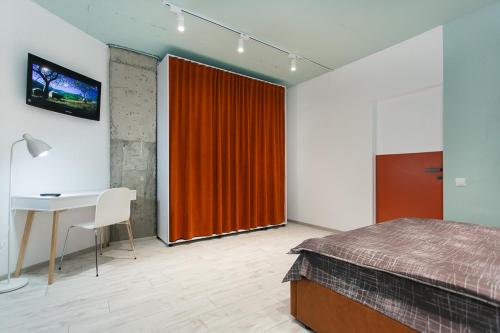 - une chambre avec un lit, un bureau et un rideau rouge dans l'établissement Vip apartmen loft, à Soumy