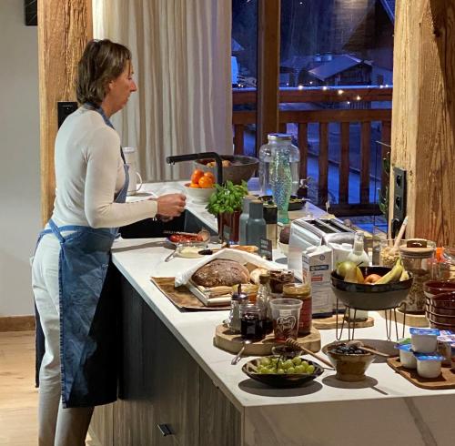 een vrouw die in een keuken staat en eten klaarmaakt bij B&B Boutique Chalet Nono in Morzine