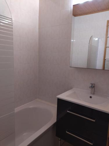 une salle de bain avec une baignoire et un lavabo et une baignoire dans l'établissement Appartement L'Ecureuil 8 pers -Prox pistes et centre village-, aux Carroz d'Arâches
