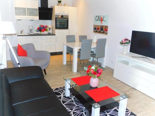 a living room with a table and a kitchen at Erdgeschoss Wohnung Watt'n Meer mit Garten in Dangast in Varel