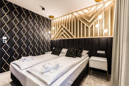 a bedroom with a bed with a black and gold wall at Aparthotel Prestige & SPA in Zakopane