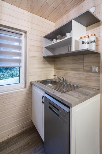 a small kitchen with a sink and a stove at DOMKI RODIS in Baligród