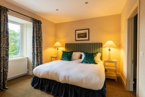 a bedroom with a large bed and a window at Isle of Eriska Hotel Spa & Island in Benderloch