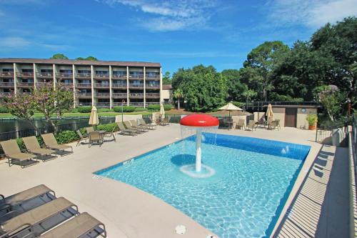 una piscina con una sombrilla roja en el agua en Island Club Condos 2 en Hilton Head Island