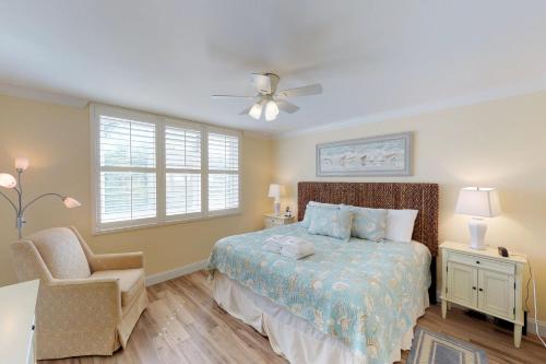 a bedroom with a bed and a chair and a ceiling fan at Island Club 1 in Hilton Head Island