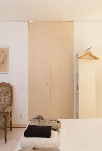 a bedroom with a bed and a chair at Darley's in Hilversum
