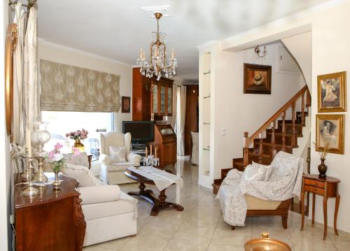 a living room filled with furniture and a chandelier at Chris Villa in Perdhika