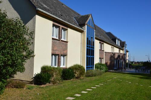 a row of houses with a lawn in front of them at The Originals City Hôtel, Aéroport Beauvais in Beauvais