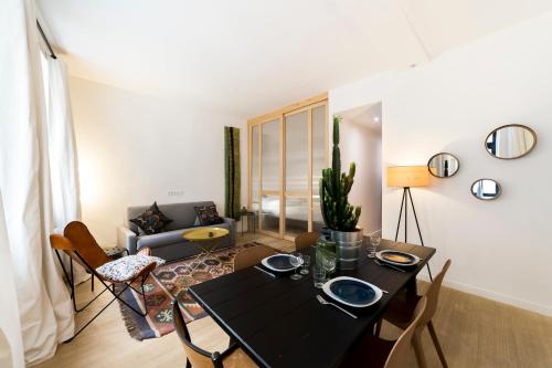 - un salon avec une table et des chaises noires dans l'établissement L'Ethnic Ambience - Superbe appartement tout confort au coeur du Vieux Lyon, à Lyon