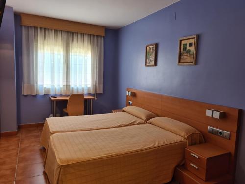 1 dormitorio con 2 camas y pared azul en Ca l'Àngel en Pinell de Bray