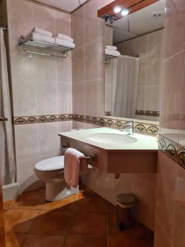 La salle de bains est pourvue d'un lavabo, de toilettes et d'un miroir. dans l'établissement Ca l'Àngel, à Pinell de Bray