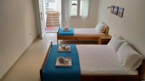 a room with two beds with towels on them at Celia`s Studio in Nea Peramos