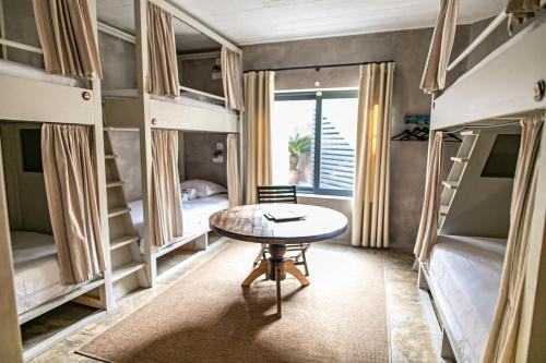 a room with bunk beds and a table in it at Surfers Lodge Peniche in Peniche