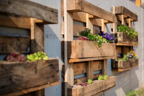 a group of wooden boxes with flowers on a wall at Apartment Bon in Kobarid