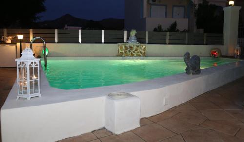 a swimming pool at night with a lantern and lights at Chris Villa in Perdhika