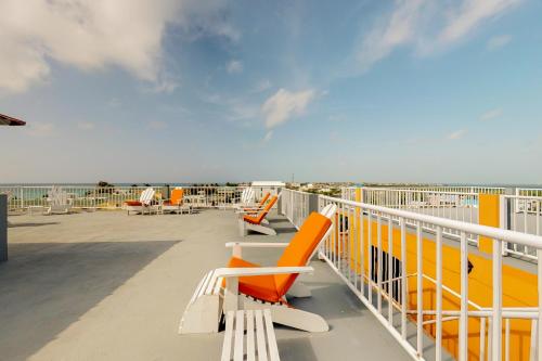 a deck with orange and white chairs and the ocean at Laguna Suites in San Pedro