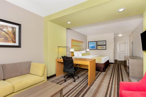 a hotel room with a bed and a desk at La Quinta by Wyndham Paducah in Paducah