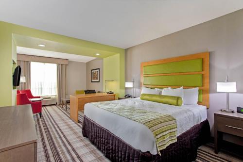 a hotel room with a large bed and a desk at La Quinta by Wyndham Paducah in Paducah