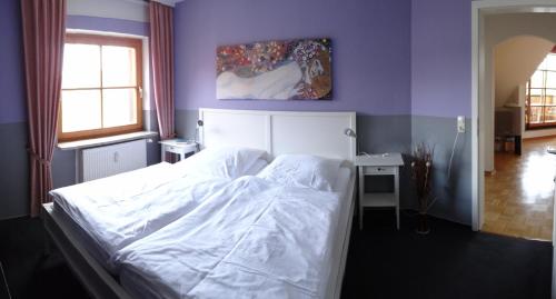 um quarto com uma cama branca e uma parede roxa em Ferienwohnung Glück Auf em Altenau