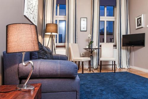 Apartamenty Grunwaldzkie في بيدغوشتش: غرفة معيشة مع أريكة زرقاء وطاولة
