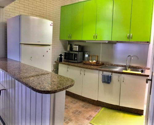 una cucina con armadi verdi e frigorifero bianco di Bruno´s House Apartment View a Pájara