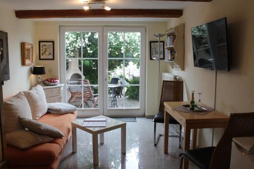 a living room with a couch and a sliding glass door at FeWo Direkt Am See - Malchow in Malchow