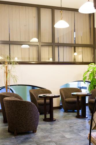 a lobby with tables and chairs in a room at Hotel St. Barbara in Tallinn