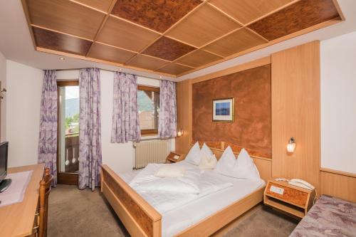 - une chambre avec un lit, un bureau et un ordinateur dans l'établissement Hotel Schmalzlhof, à Rasun di Sopra