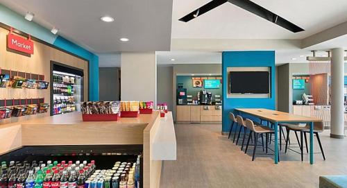 a store with a cafeteria with a table and chairs at avid hotels - Columbus Northwest - Hilliard by IHG in Hilliard