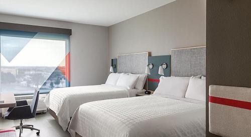 a hotel room with two beds and a window at avid hotels - Columbus Northwest - Hilliard by IHG in Hilliard
