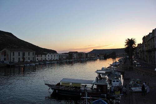 a group of boats docked in a river at sunset at Sa Domo De Alene in Bosa