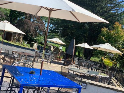 a blue table with an umbrella and some tables and chairs at Uplands Inn Cartmel in Cartmel