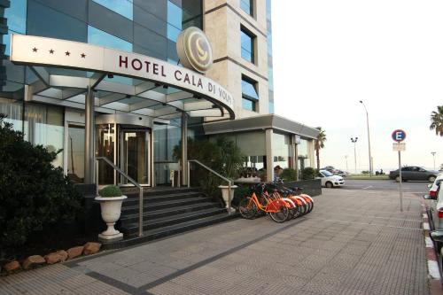um edifício de hotel com bicicletas estacionadas fora dele em Cala di Volpe Boutique Hotel em Montevidéu