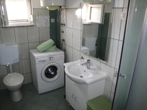 un bagno con lavatrice e lavandino di Apartments Klanac a Zara (Zadar)
