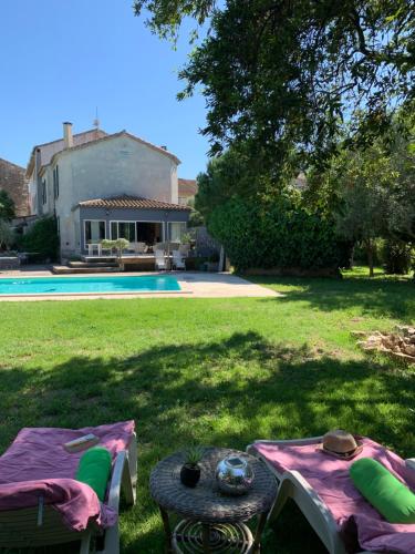 een achtertuin met een picknicktafel en een huis bij Le Jardin de LaCoste in Narbonne