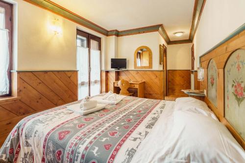 um quarto com uma cama grande num quarto em Hotel Alemagna em San Vito di Cadore