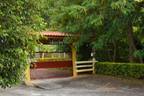 a gate with a fence in front of a house at Pousada Colonetti in Lindóia