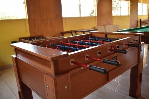a wooden foosball table with darts in a room at Pousada Colonetti in Lindóia