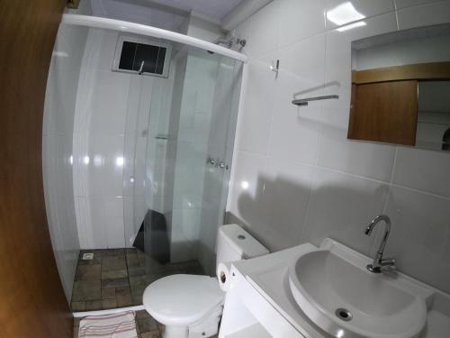 a bathroom with a shower and a toilet and a sink at Hotel Zagonel in Chapecó